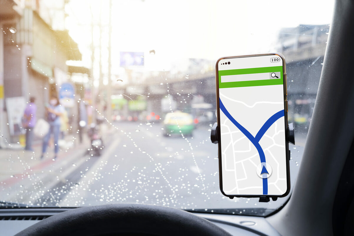 Telefon z aplikacją nawigacyjną na desce rozdzielczej w trasie