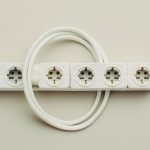 Ochronnik przepięciowy 230V zamontowany w panelu elektrycznym kampera z widocznymi kablami i diodami LED