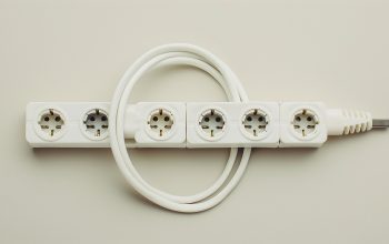 Ochronnik przepięciowy 230V zamontowany w panelu elektrycznym kampera z widocznymi kablami i diodami LED